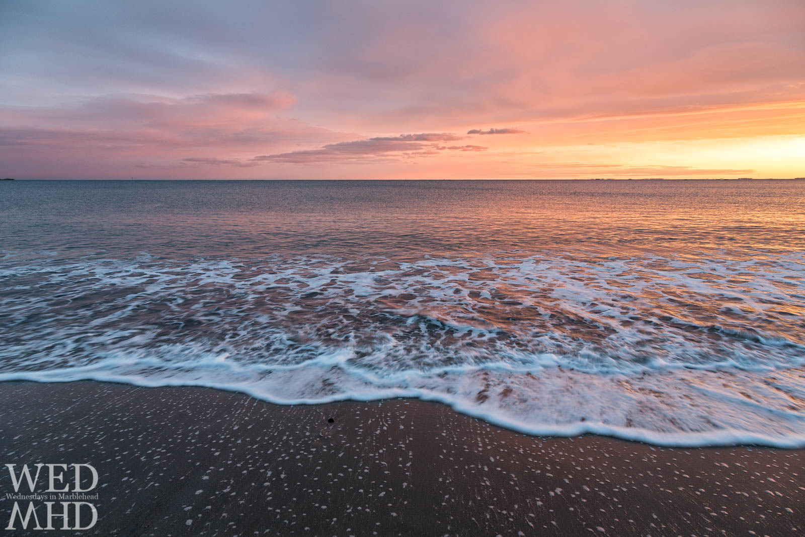 wave approaches shore at sunset on Devereux Beach