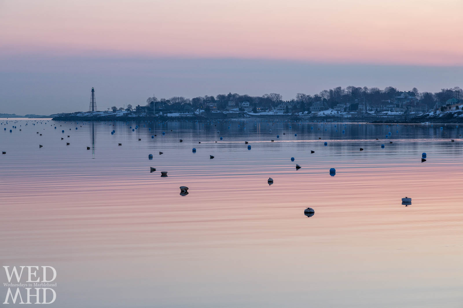 Ripples in the water break up the reflection of dawn's colors in Marblehead Harbor