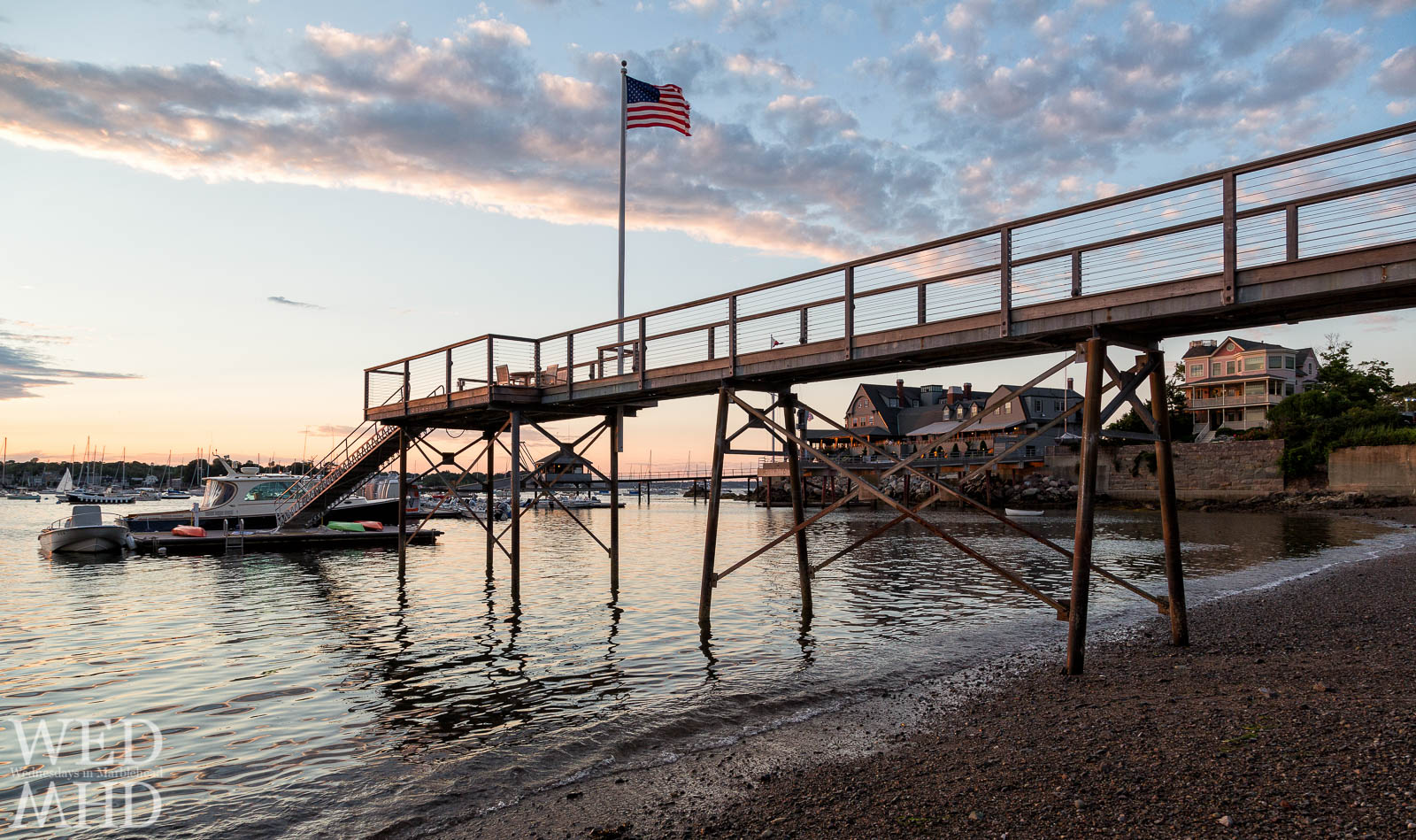 Old Glory flies high from a private pier along Marblehead Neck with the Corinthian Yacht Club seen in the distance