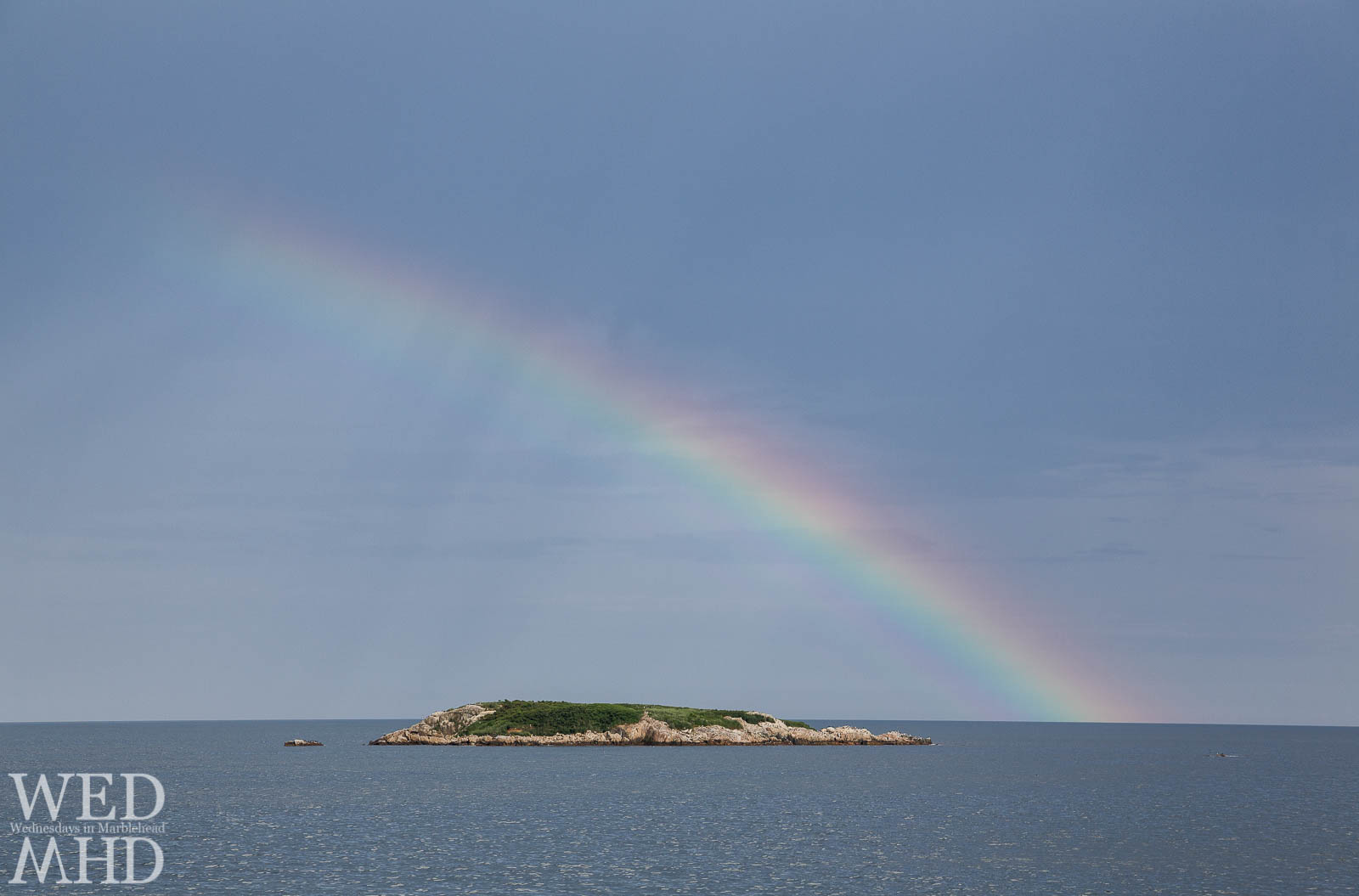 A midsummer rainbow forms over Ram's Island off Marblehead