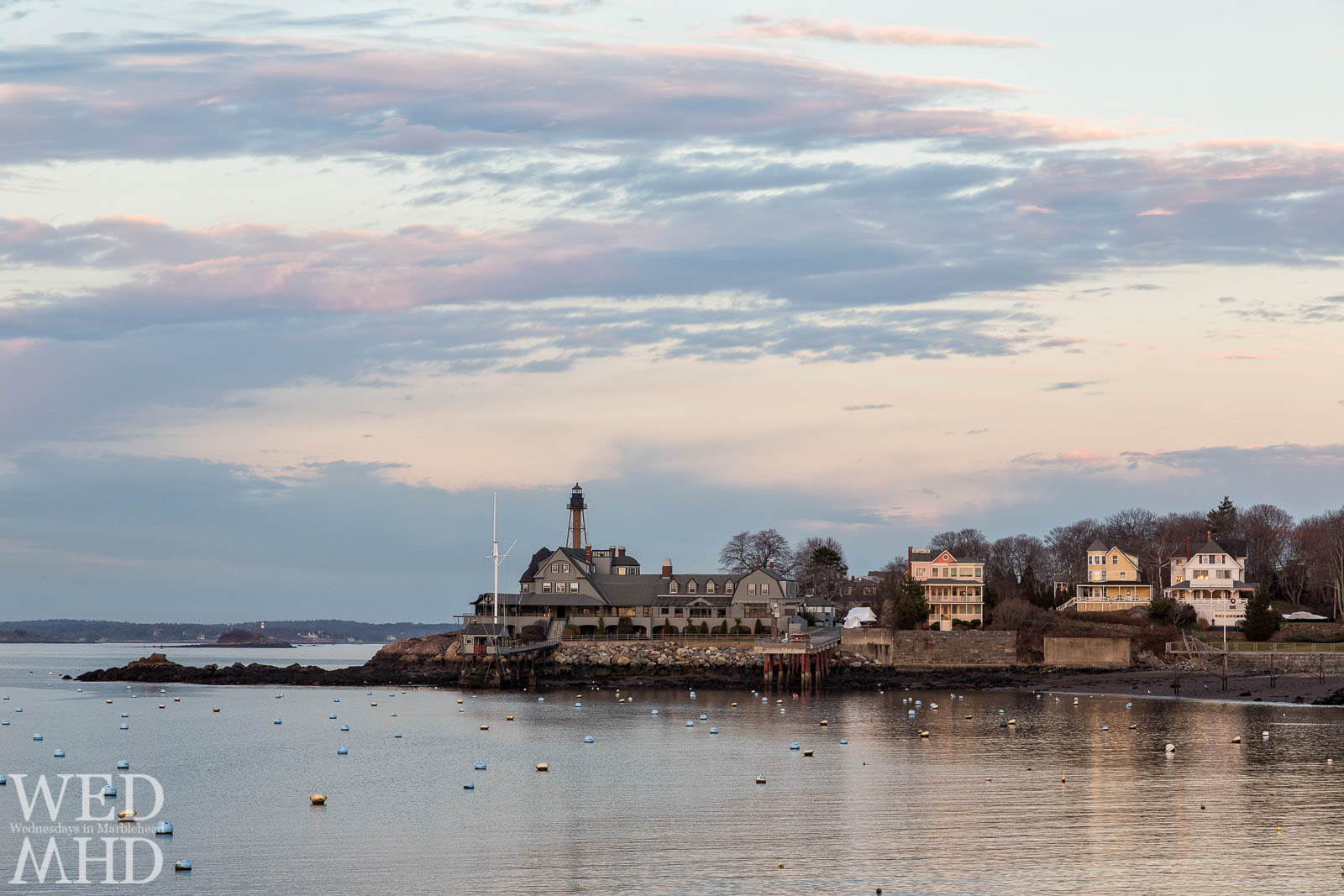 The last rays of sunlight reflect off Marblehead Light, the Corinthian Yacht Club and homes on the Neck captured on Christmas Eve in Marblehead
