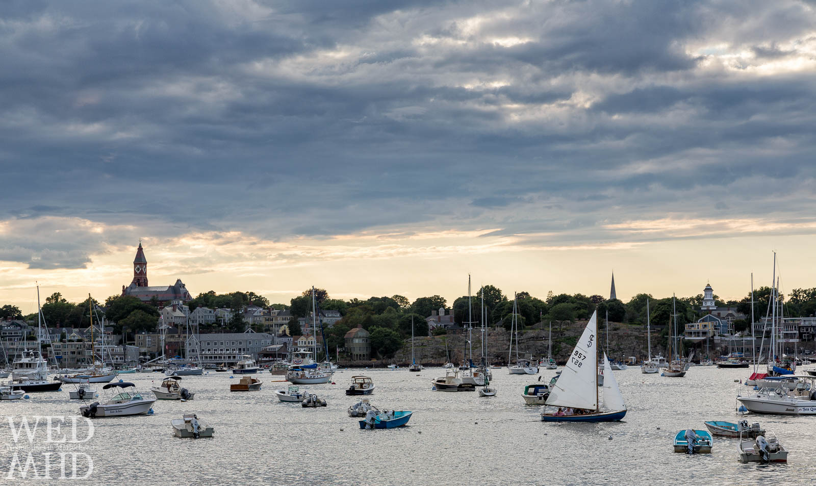 A sailboat makes its way through Marblehead Harbor past familiar landmarks on a perfect Summer evening in Marblehead