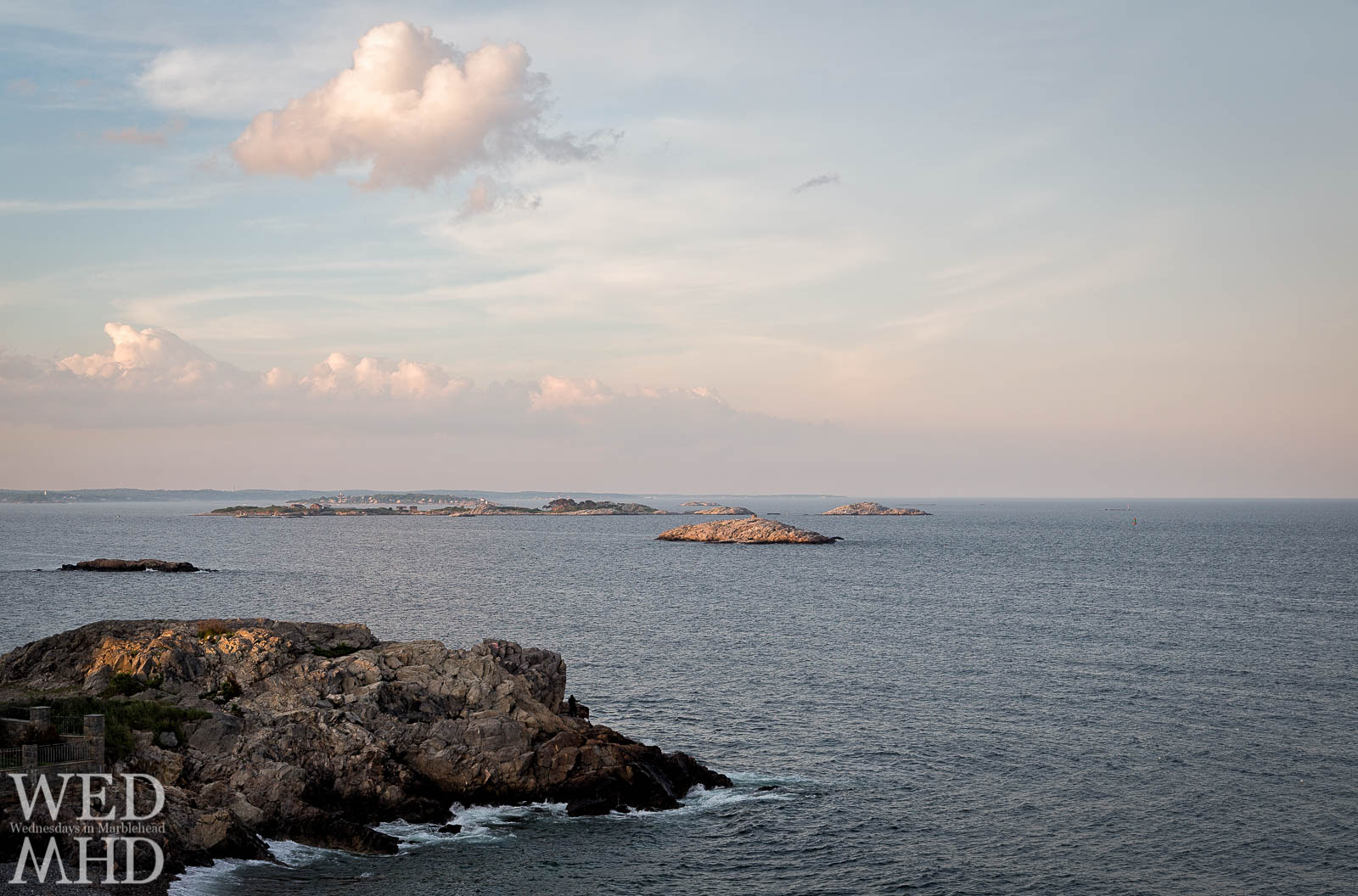 Castle Rock and a single cloud reflect the last light of sunset on a warm June day