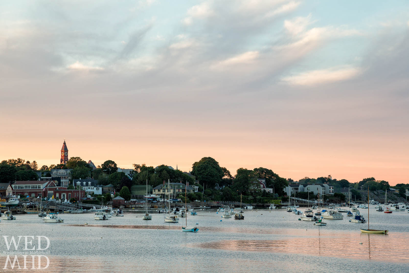 Patches of calm water form into pools of light in Marblehead Harbor on an evening in June
