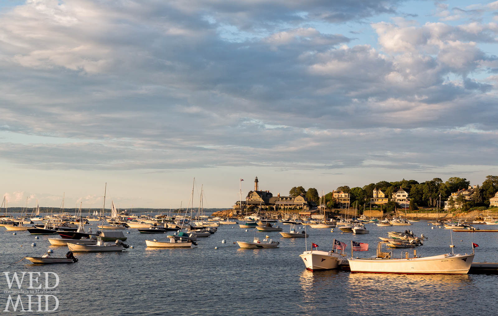 Waving flags on two boats at the launch for the Eastern Yacht Club signal windy conditions on a warm Summer evening