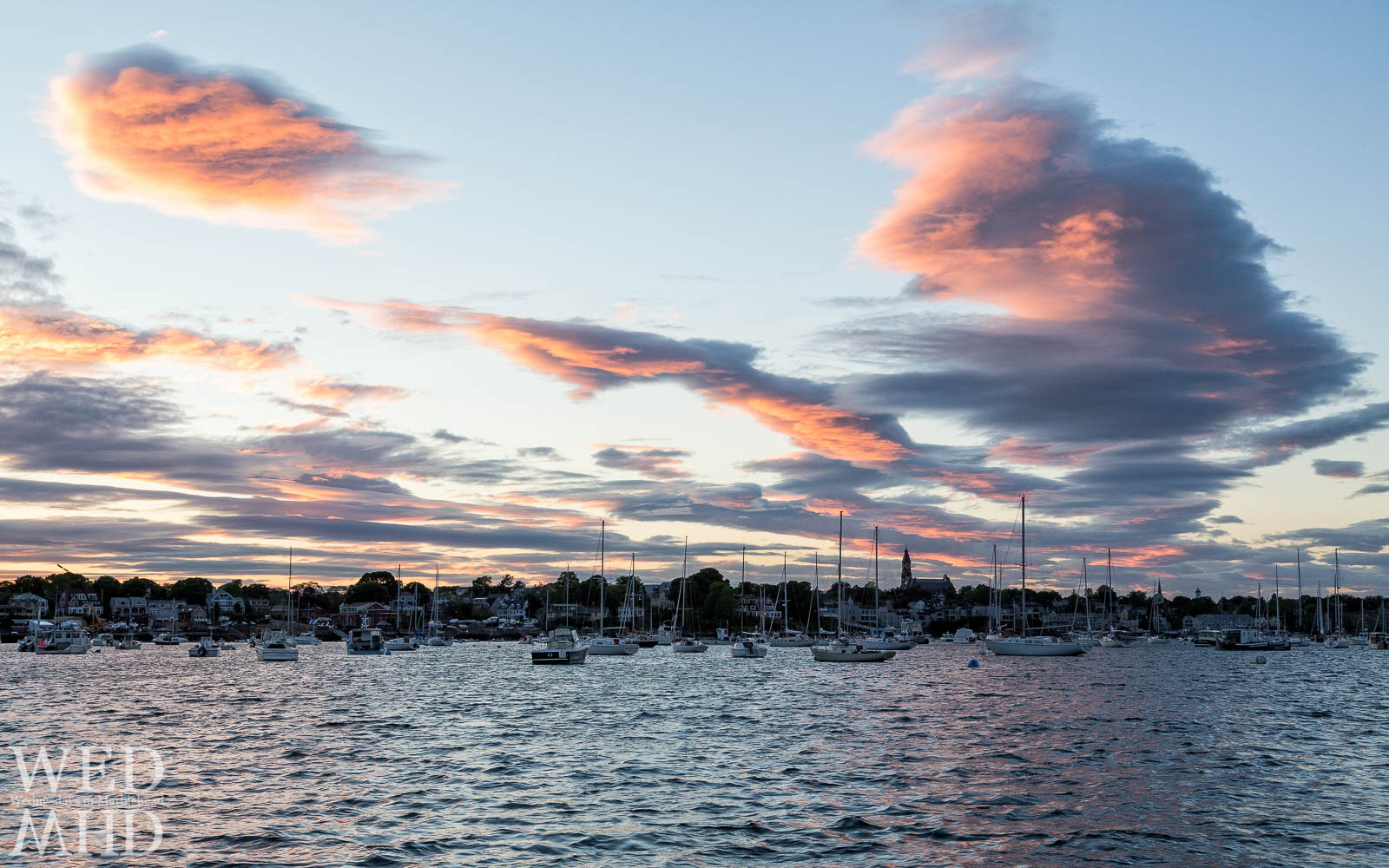 Sunset sets the clouds on fire over Marblehead harbor as viewed from Riverhead Beach
