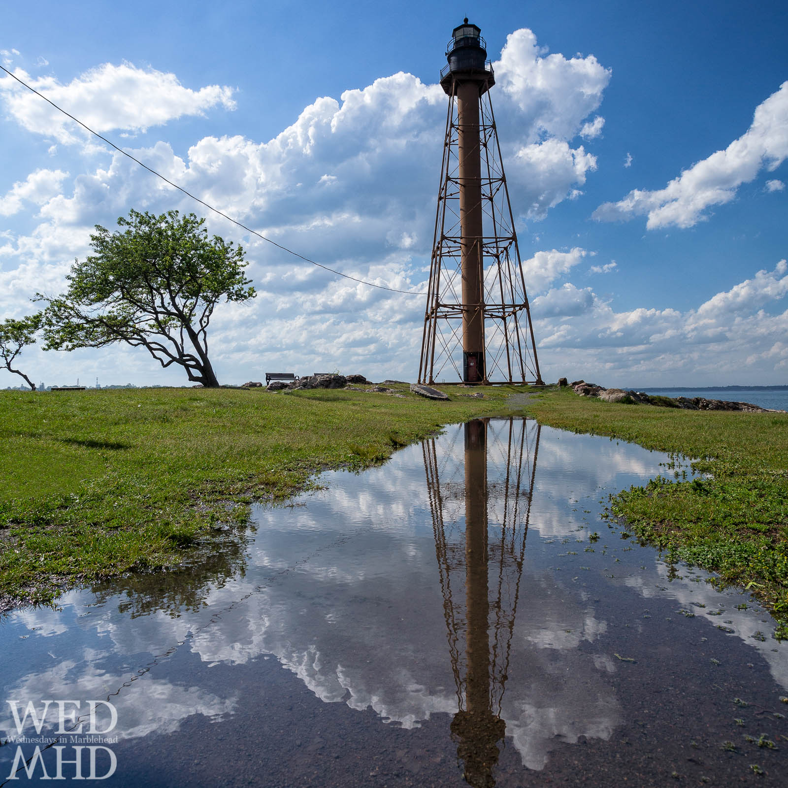 Marblehead Lighthouse reflecting in rainwater between storms