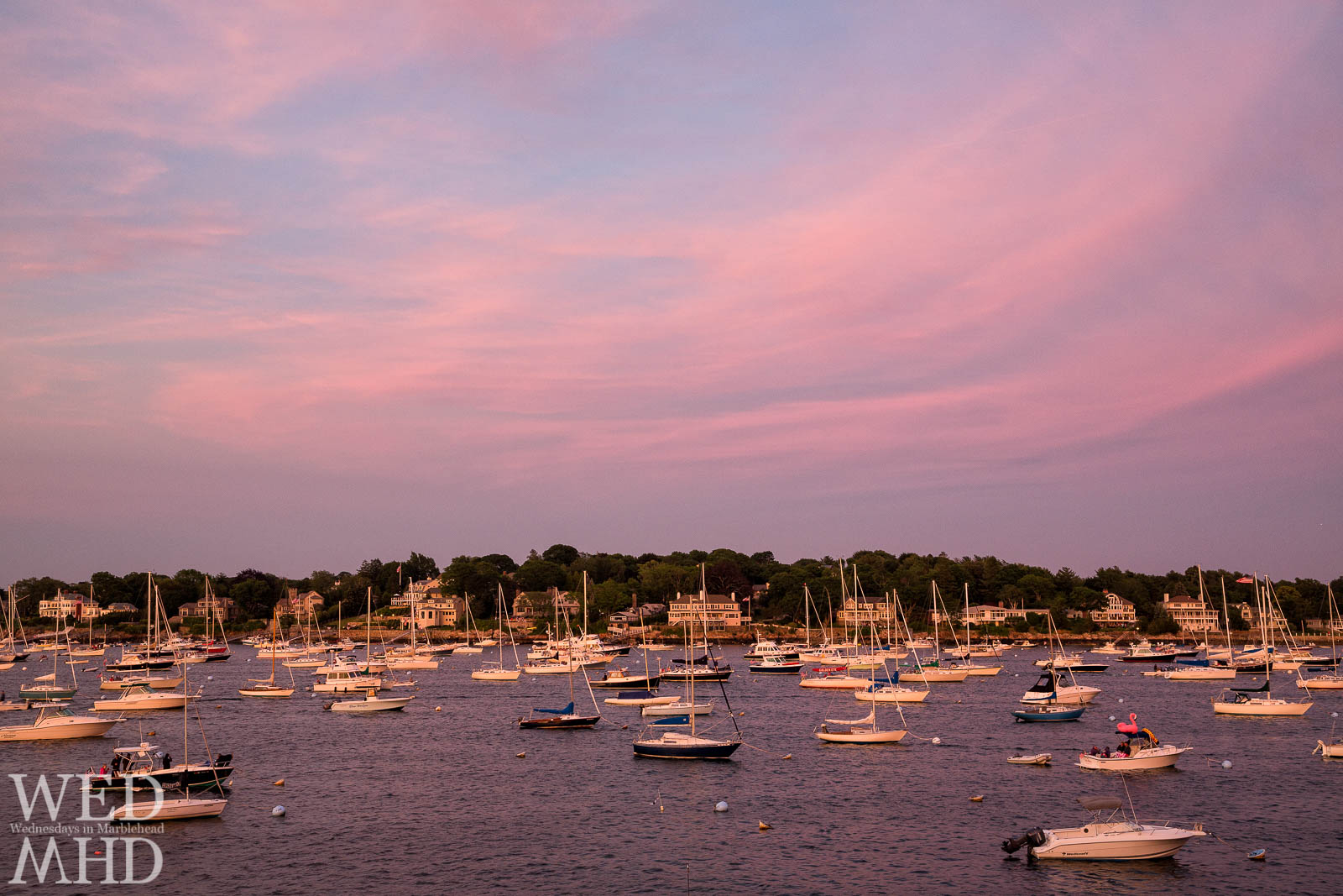 Pink flamingo sunset over Marblehead Neck matches the pink flamingo atop a boat