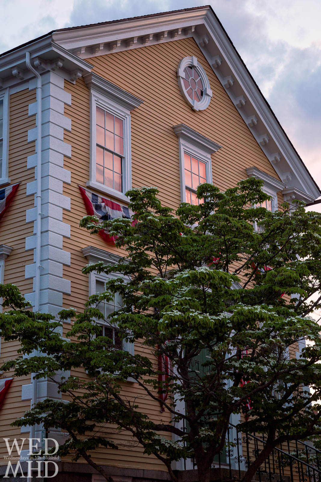 Old Town House is bathed in a pink glow reflecting in its windows just after the sun sets