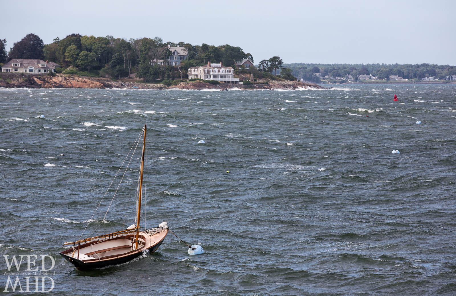 A lone boat caught fighting the current created by an offshore storm while moored at the mouth of Marblehead Harbor