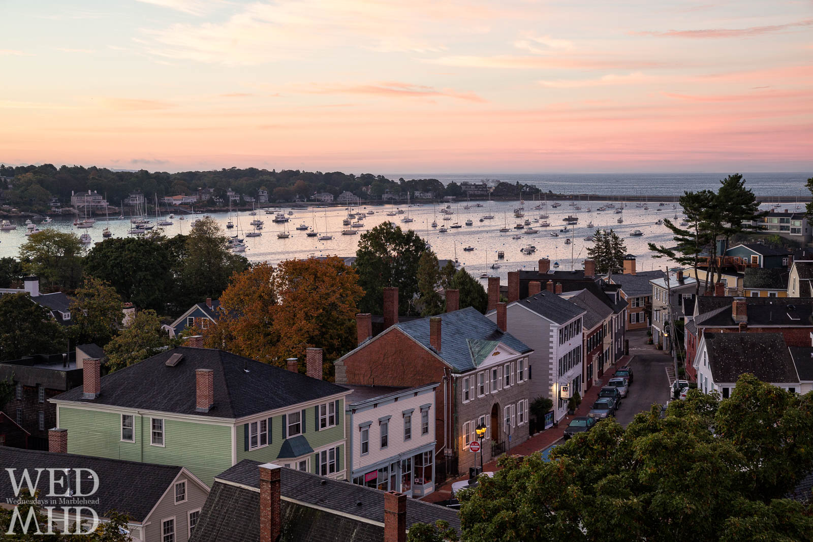 A view from atop St. Michaels Church reveals a sleepy downtown Marblehead with Hooper street and the harbor below bathed in morning color.