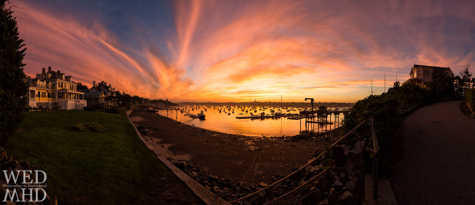 A September sunset creates a breathtaking view from Corinthian Lane as captured in this panorama of stately houses, a harbor filled with boats and reflecting golden light