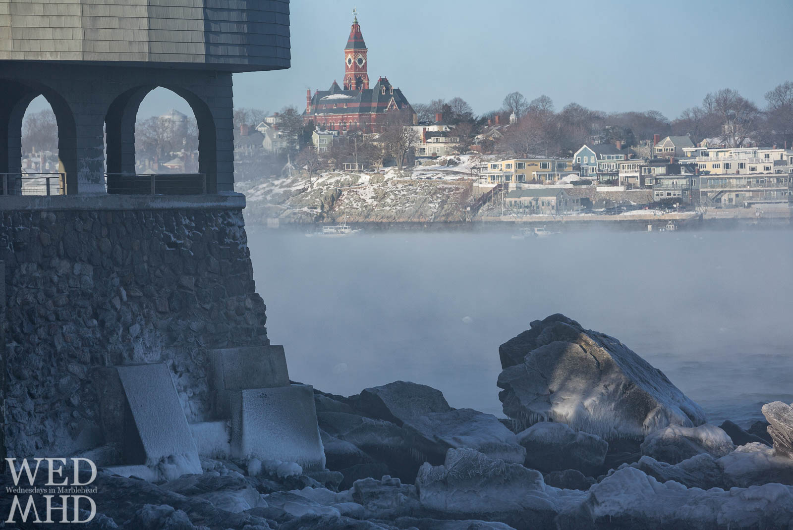 Rime ice forms along the base of the Corinthian Yacht Club with sea smoke creating fog in Marblehead Harbor