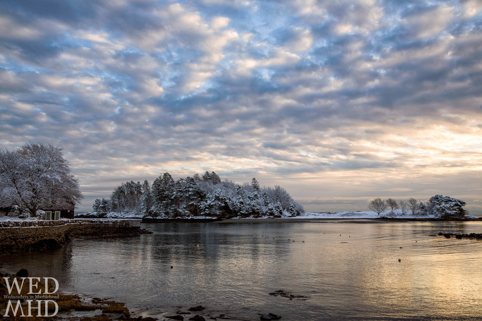 A dusting of snow on Brown's Island shines in the morning light reflected in the waters of Fisherman's Beach