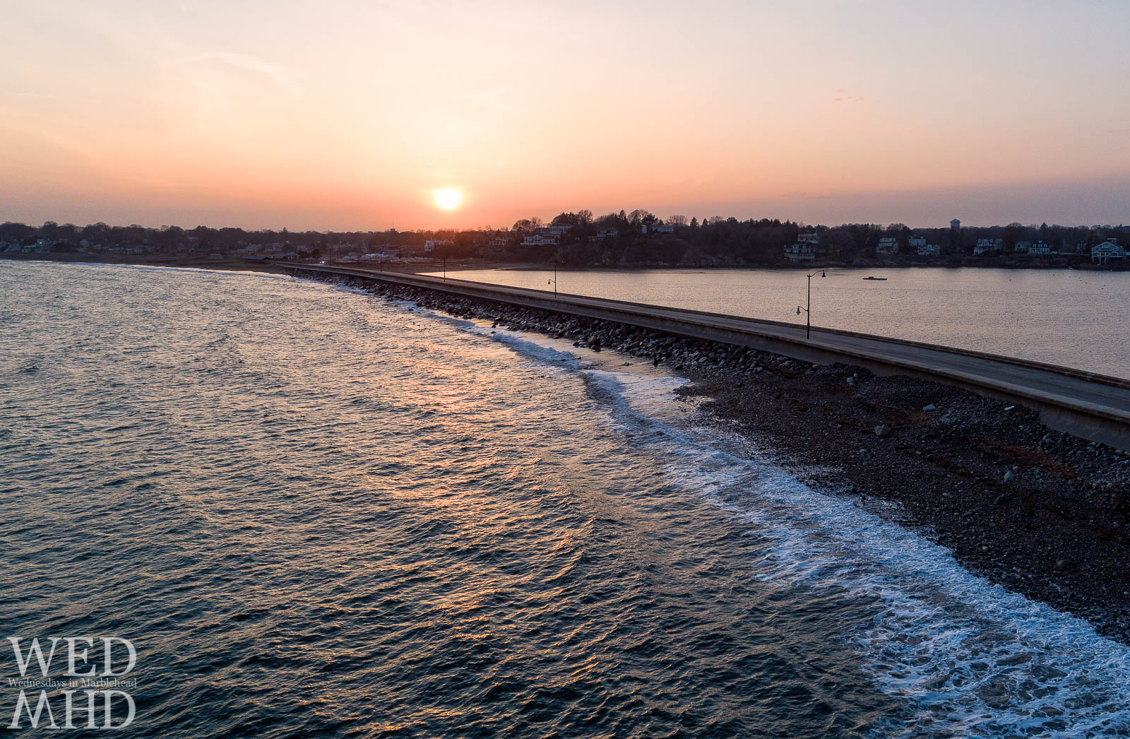 A golden sunset reflects on the Atlantic Ocean in this aerial view over the causeway