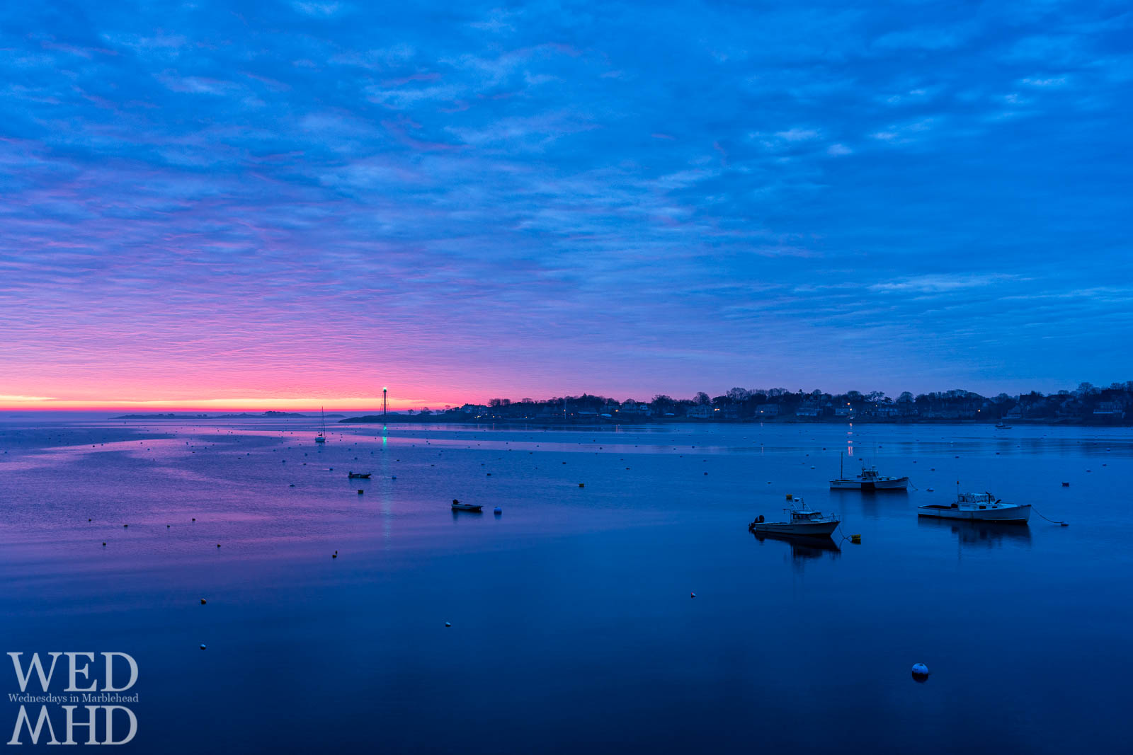 Dawn's colors break up the early morning blue hour on an empty harbor yet to fill with boats for the season