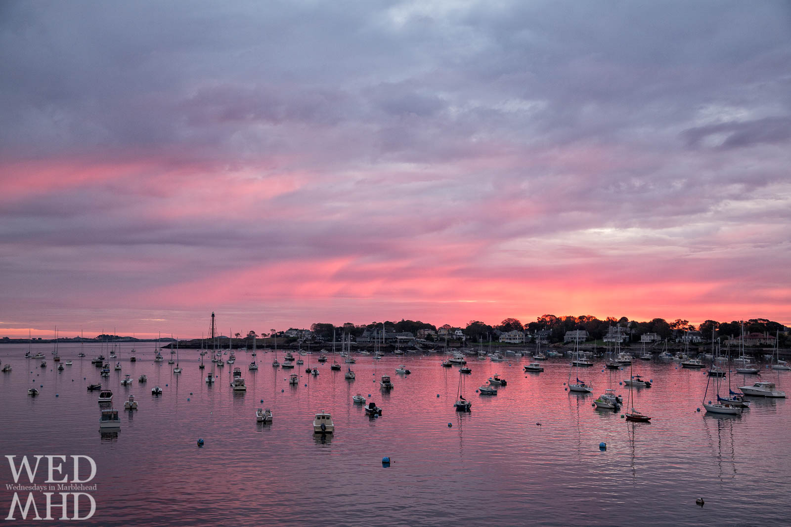 An October sunrise bathes Marblehead harbor in perfect pink light.