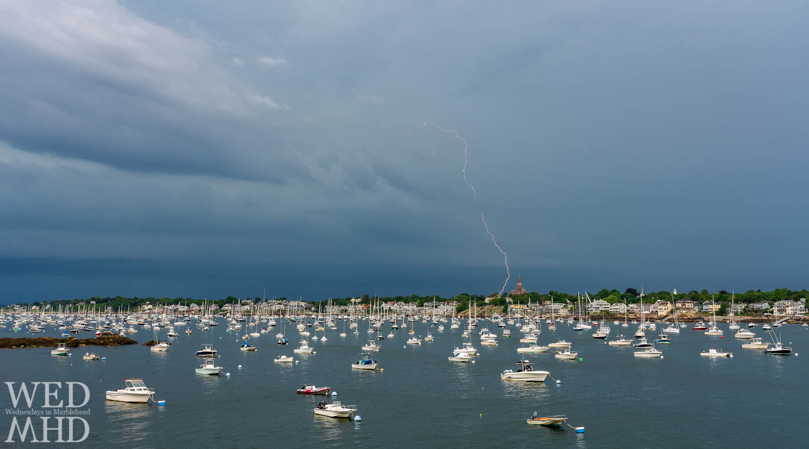 The first summer storm in Marblehead brings a bolt of lightning near Abbot Hall and over a harbor filled with boats
