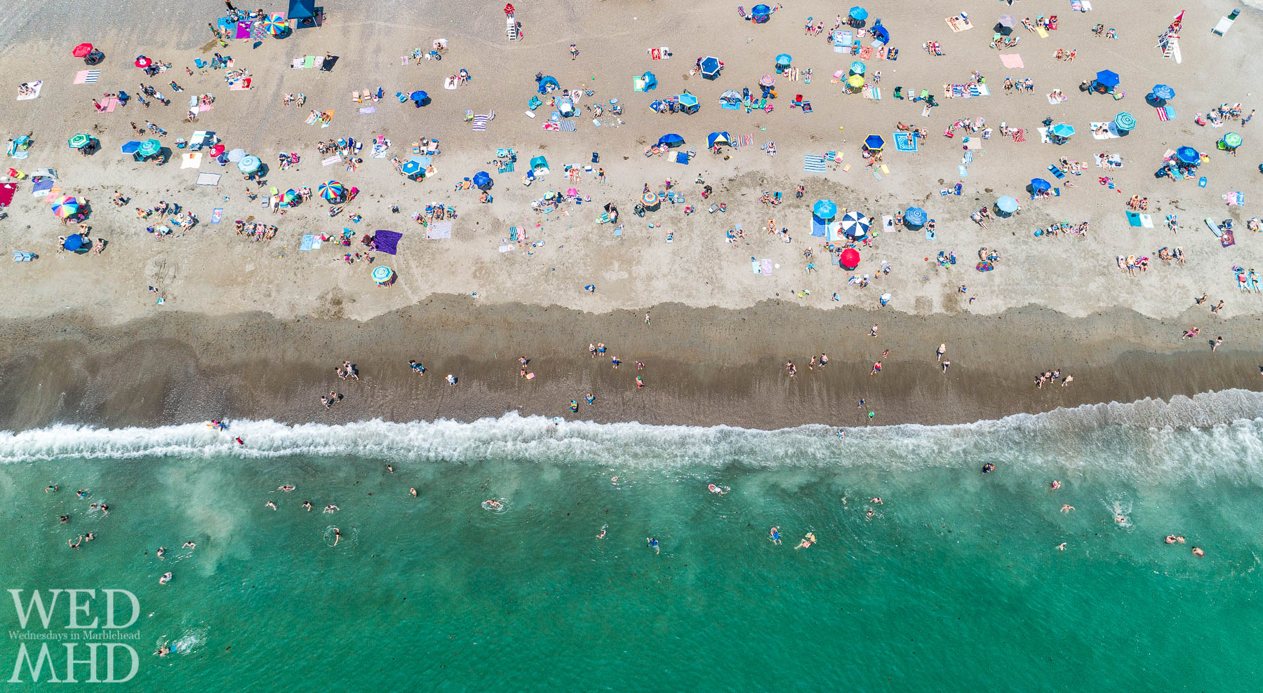 An aerial view of Devereux Beach on a hot summer day captures a mix of sunbathers and ocean swimmers. We will hopefully have a large beach party when the threat of COVID-19 has passed.
