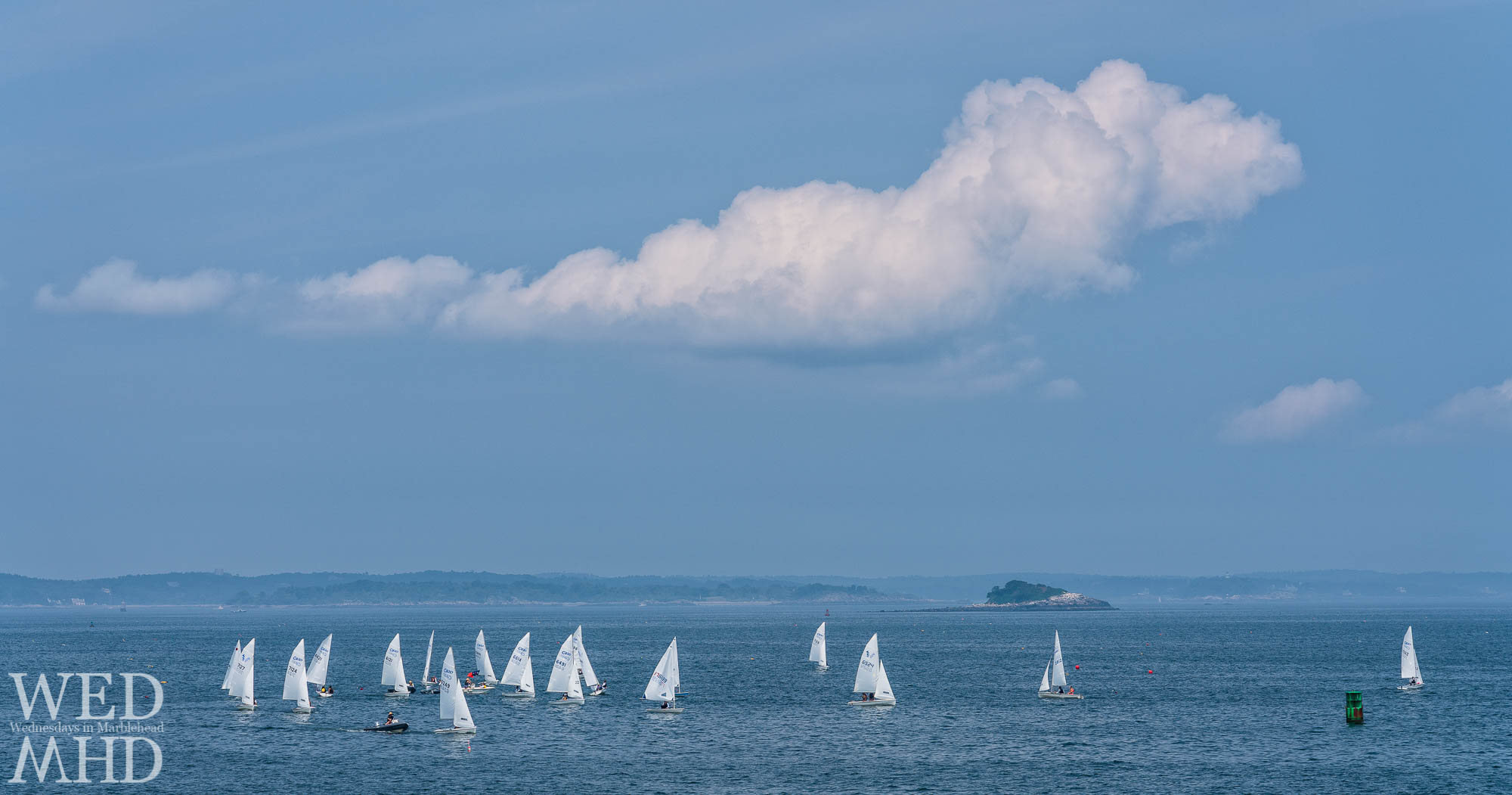 C420s sail in the waters off Marblehead Harbor with a few clouds overhead