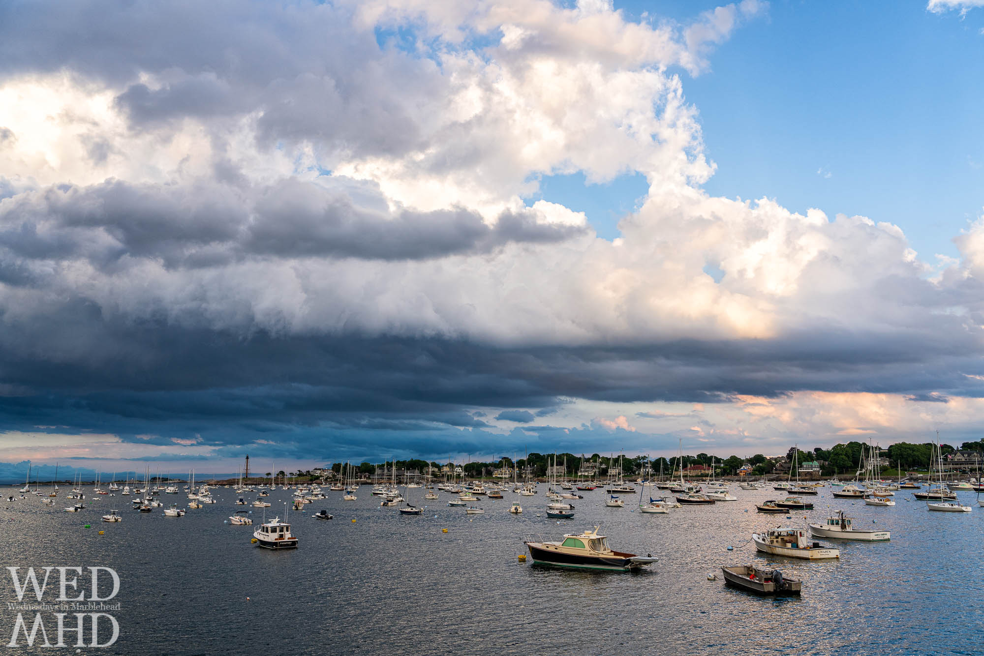 Storm clouds gather with boats in their moorings pointing toward the interesting sky as the show is about to begin